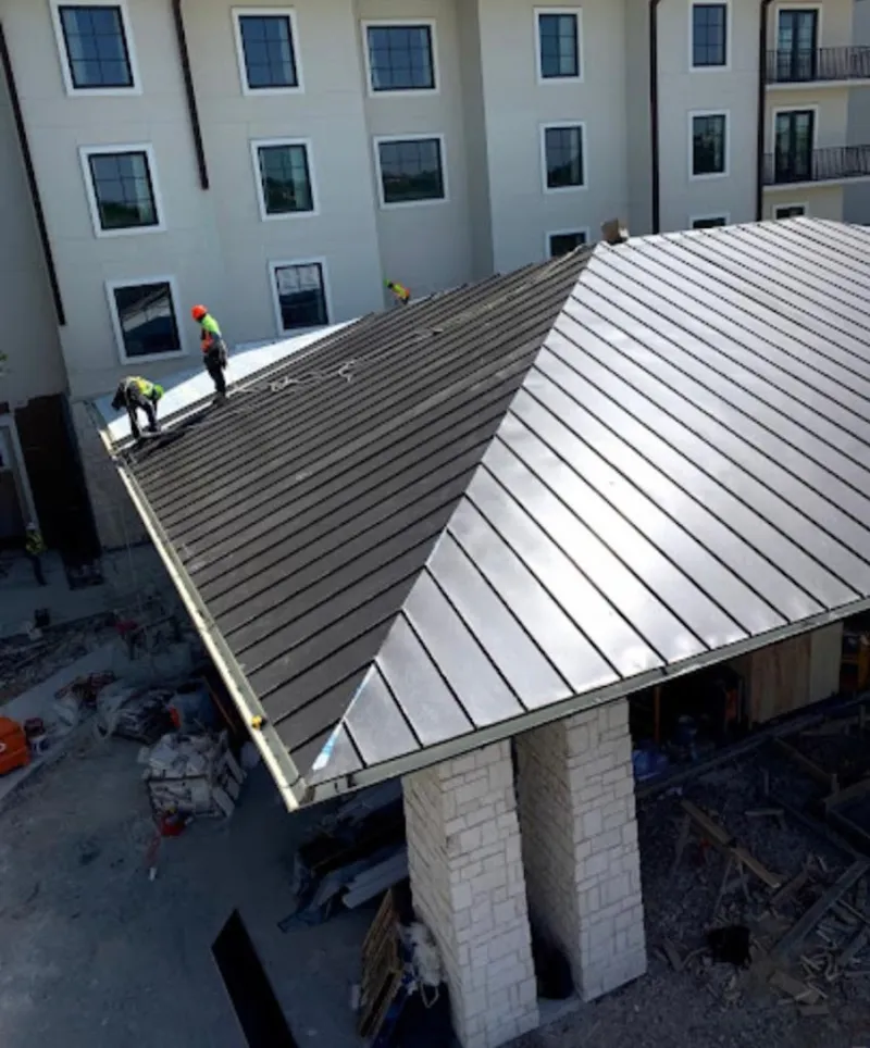 Crew installing standing seam metal roof panels on a commercial project in Hopatcong